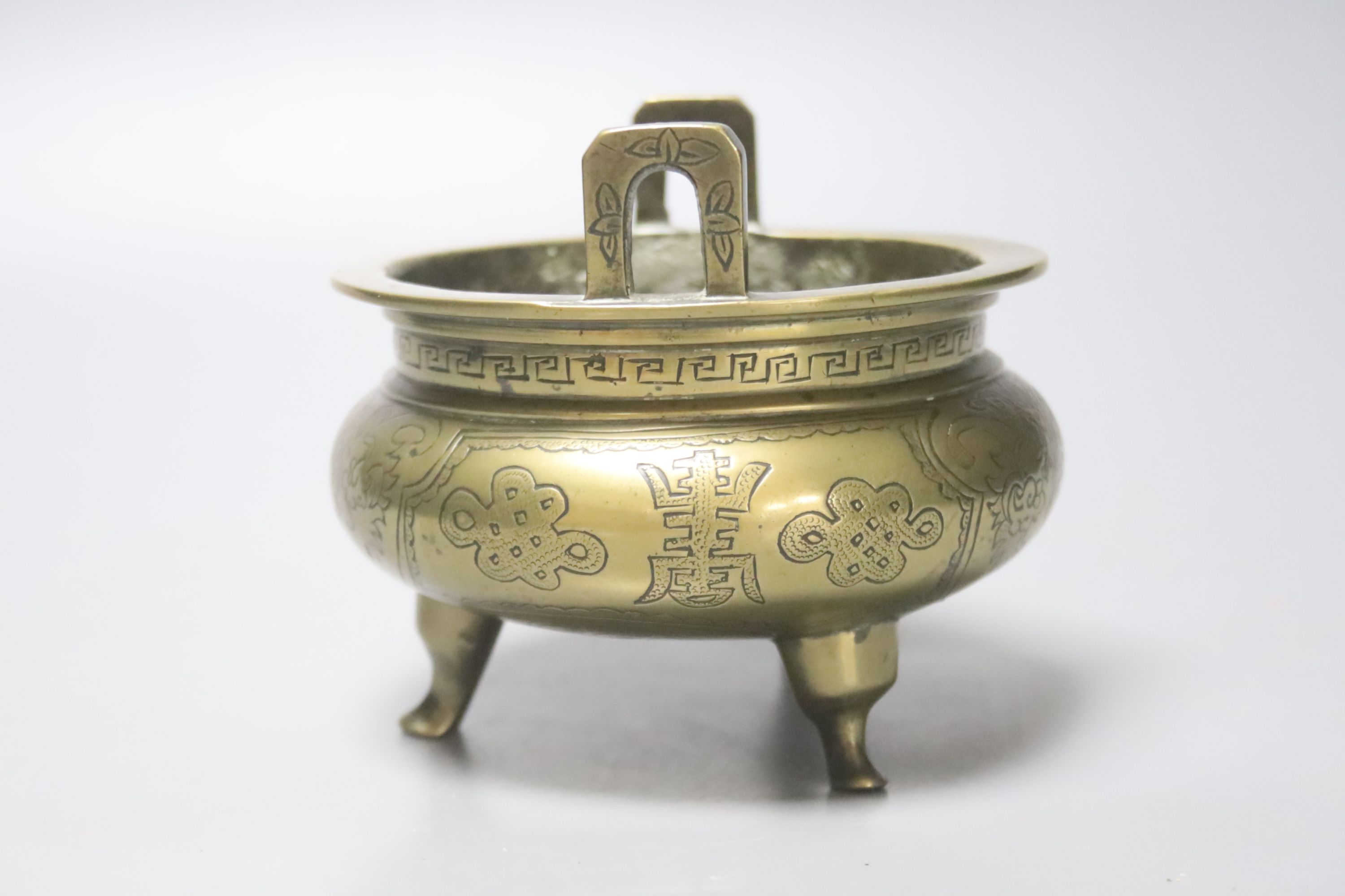 A 19th century Chinese engraved bronze tripod censer, Xuande mark to base, height 11cm